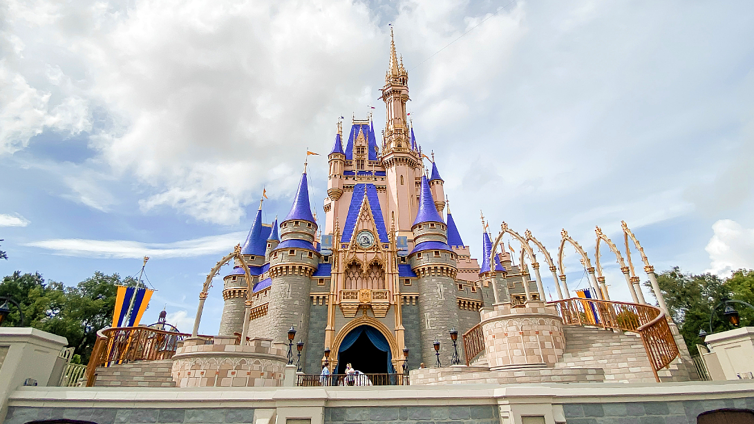 Cinderella Castle at Walt Disney World in Florida, featuring majestic spires and ornate detailing under a partly cloudy sky.